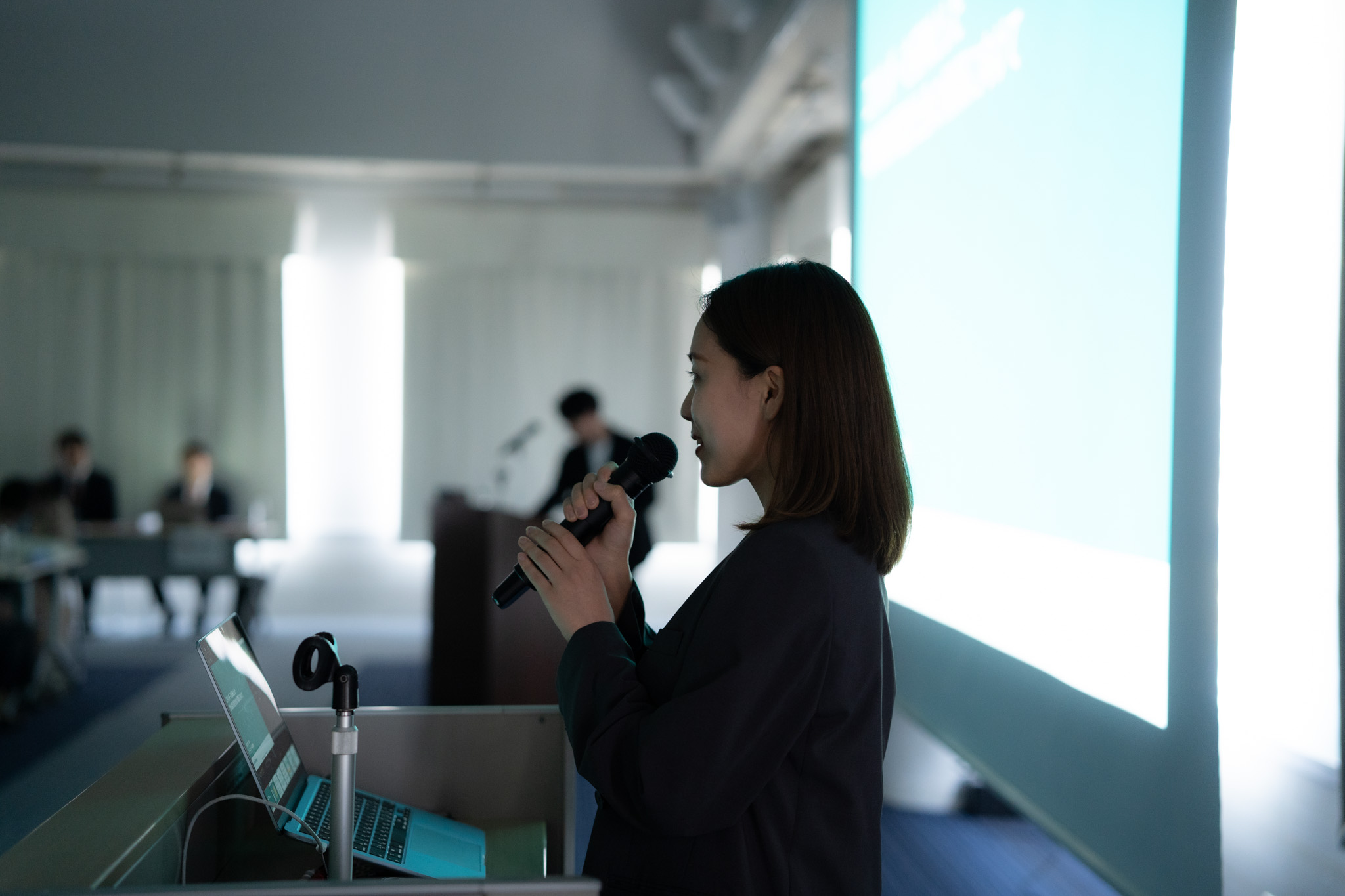 黒いスーツの女性企業担当者による会社説明