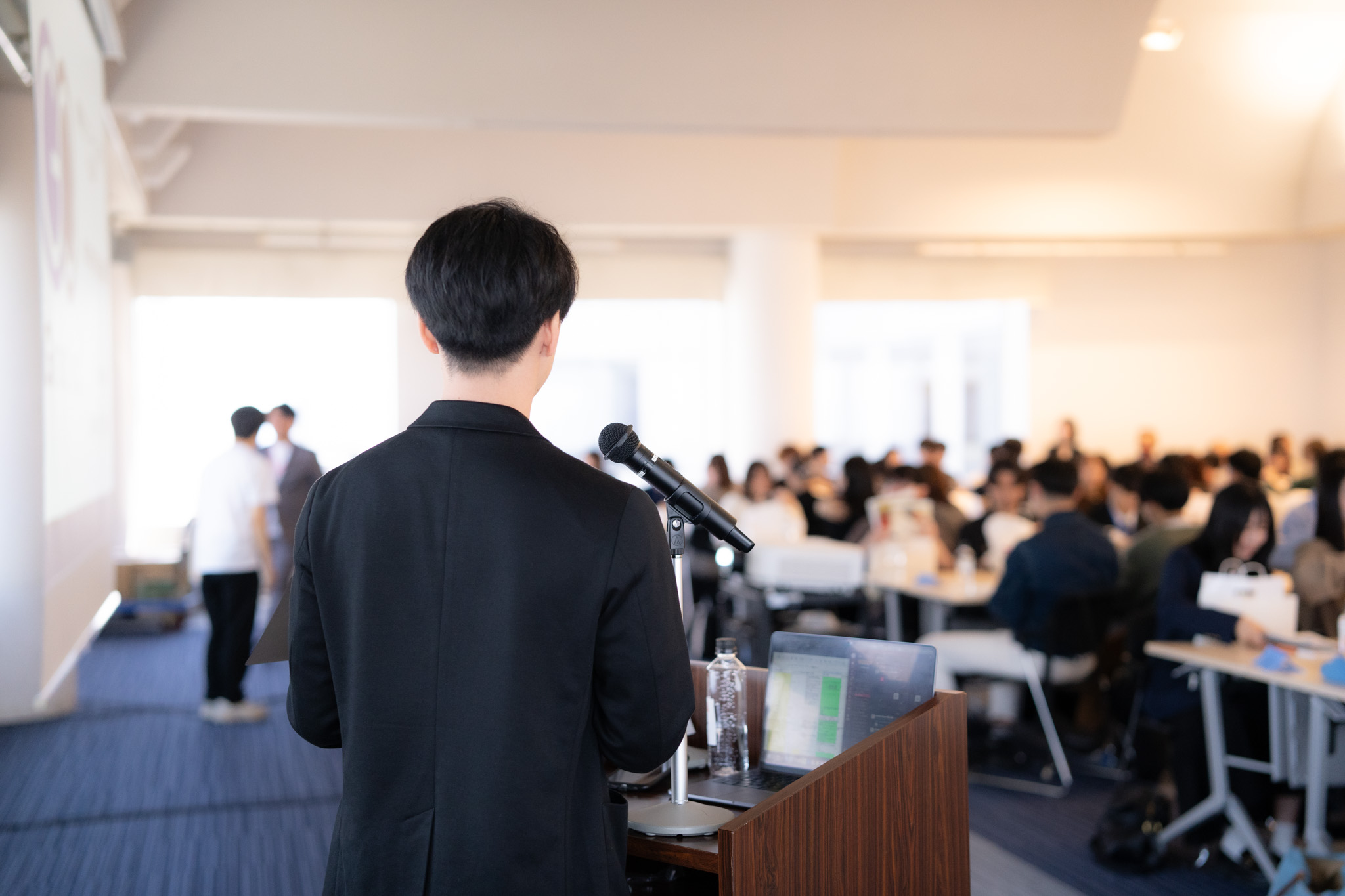 参加者に向けて話す司会者