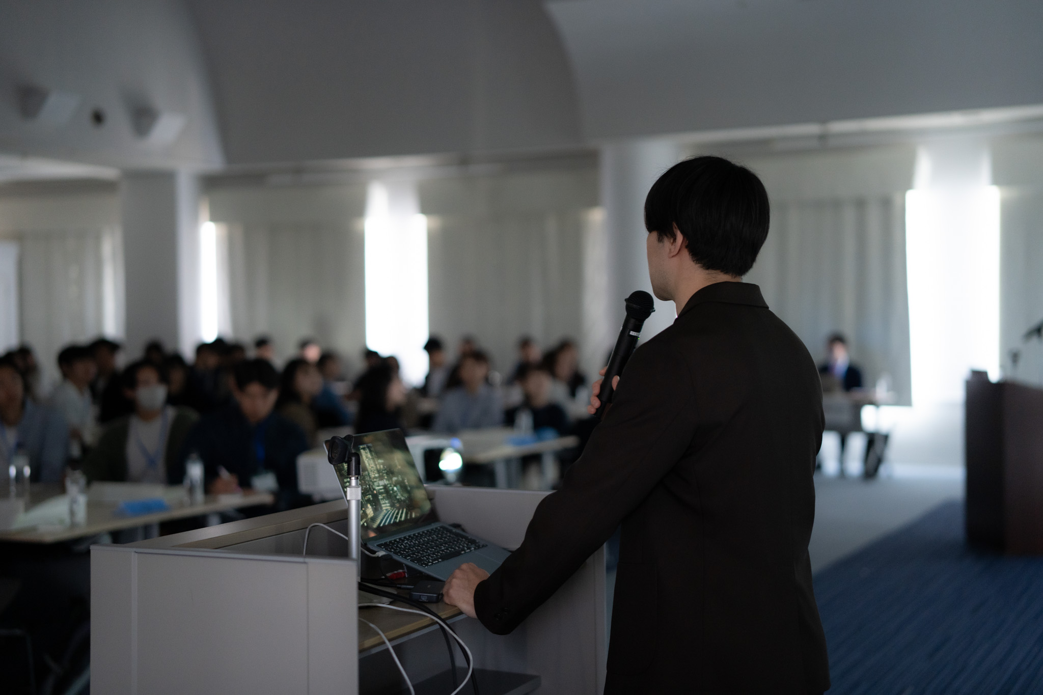 企業担当者による参加者への説明（後ろ姿）