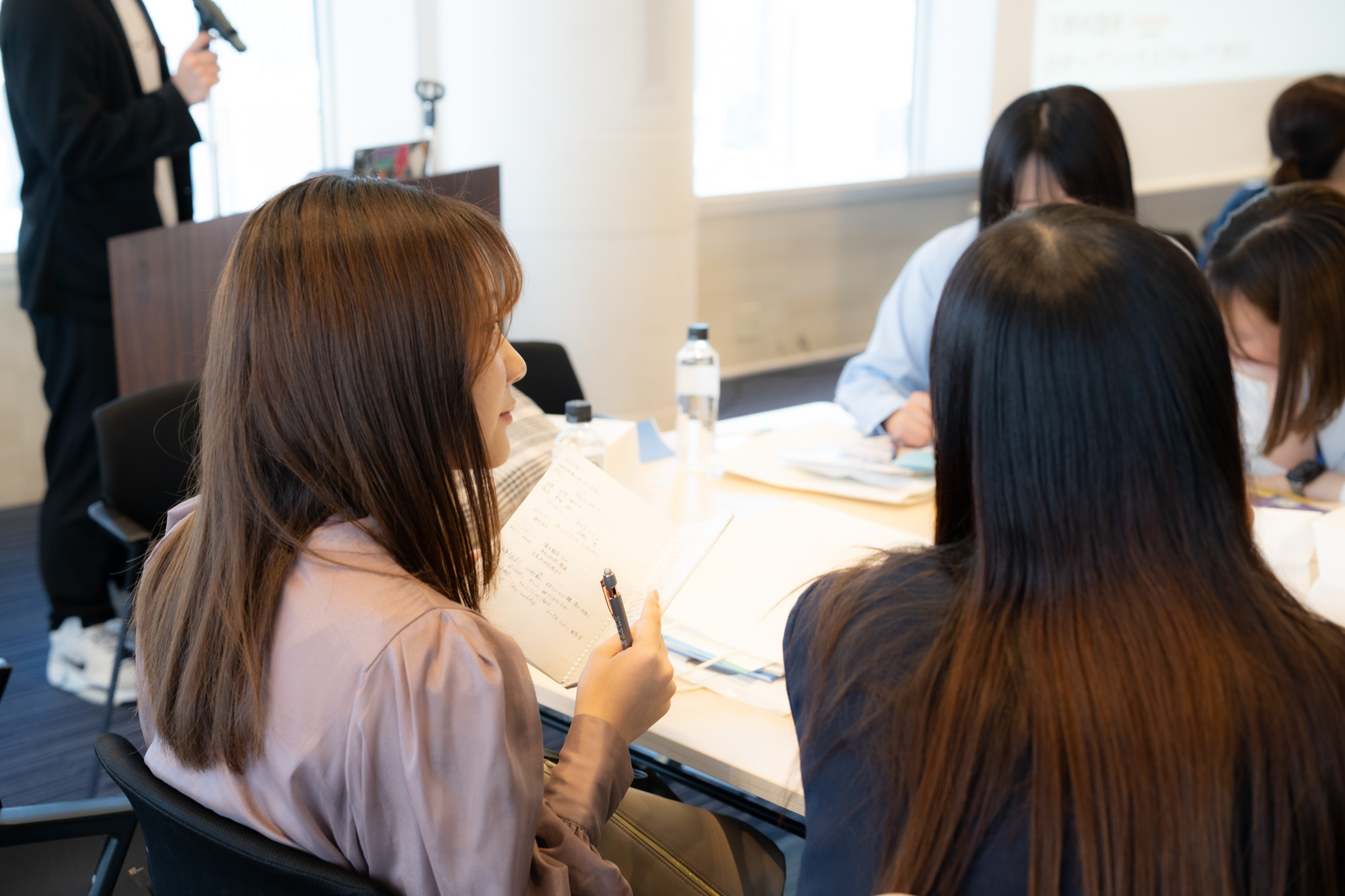資料を確認しながらメモを取る学生